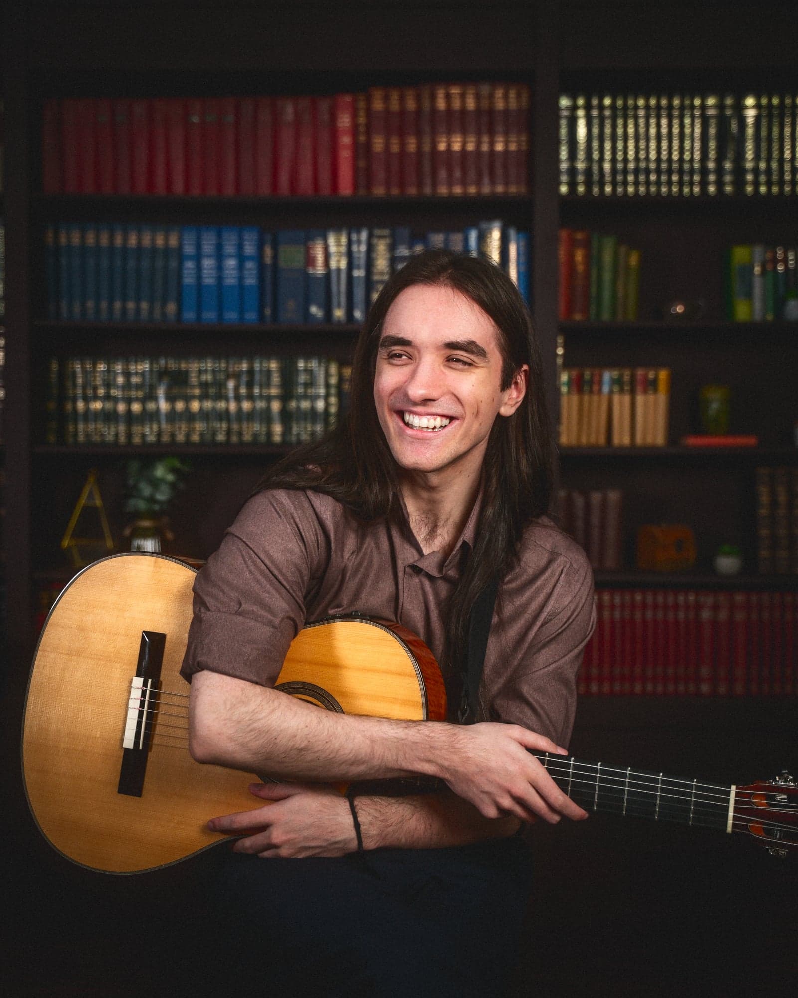 Sam laughing holding guitar