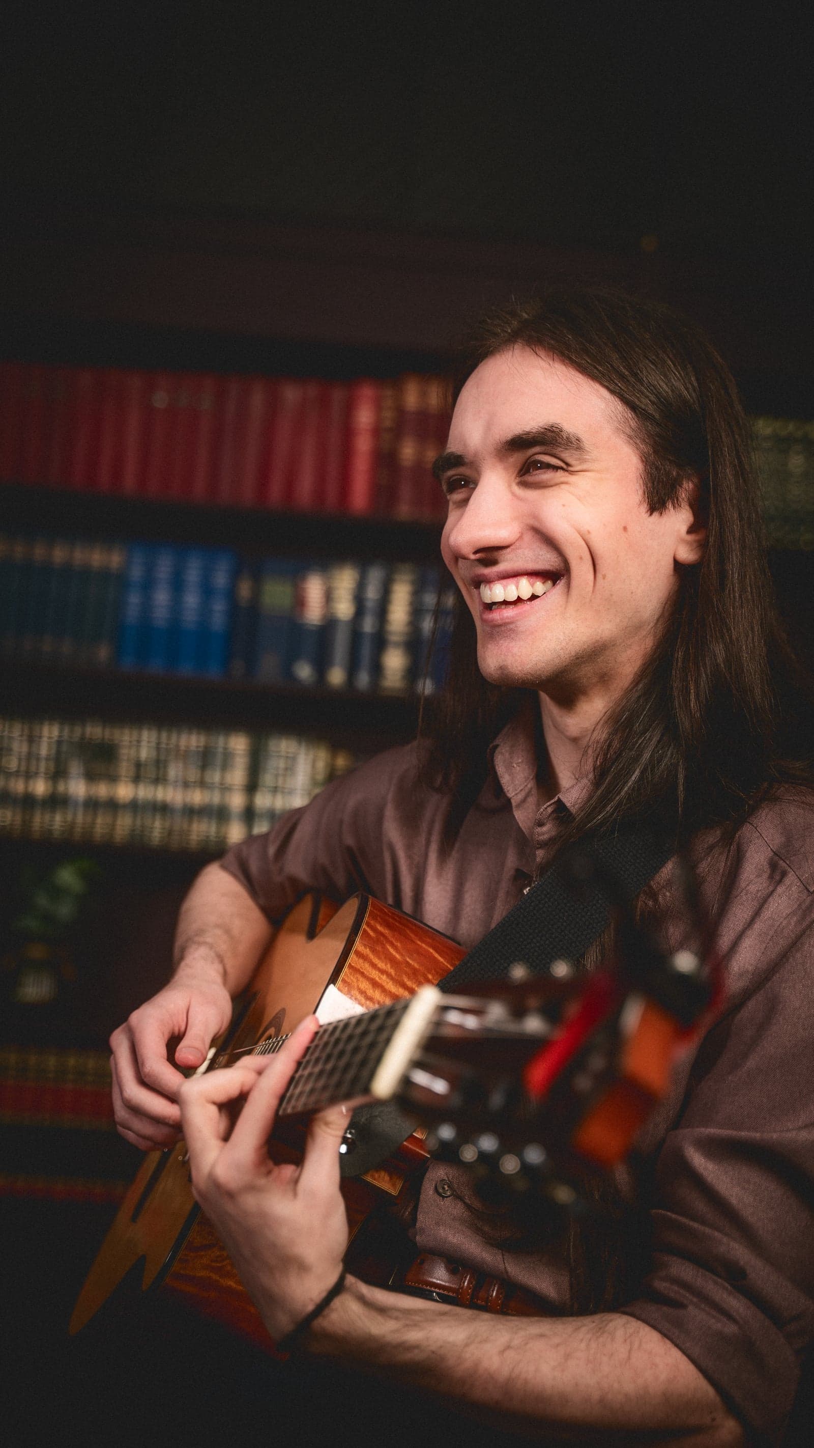 Sam looking up laughing with guitar