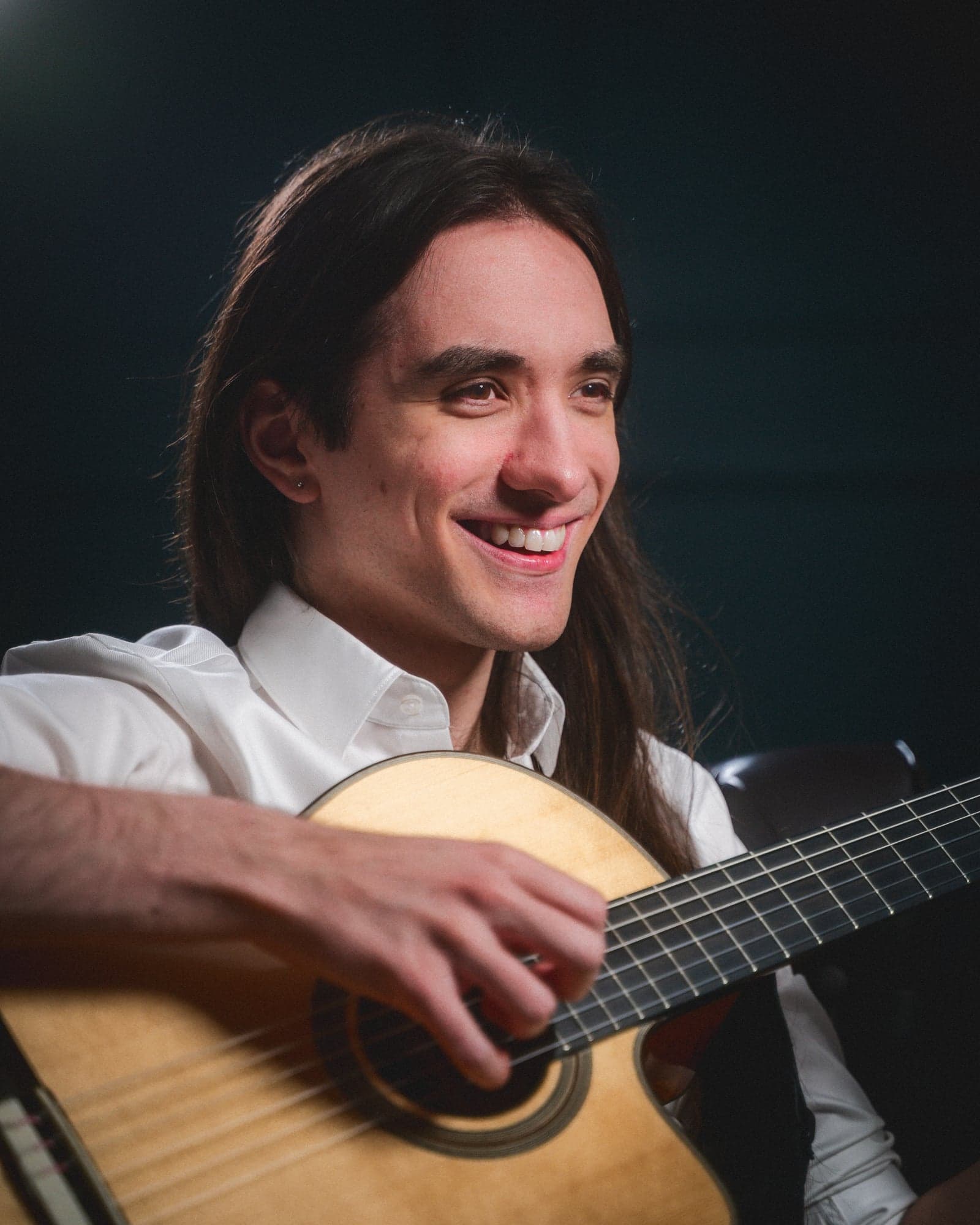 Sam playing guitar, white shirt